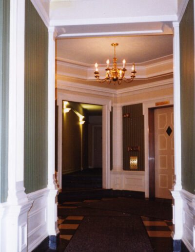 Classic hallway with chandelier and striped wallpaper.