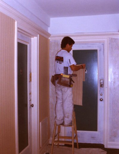 Man painting a wall inside a home.