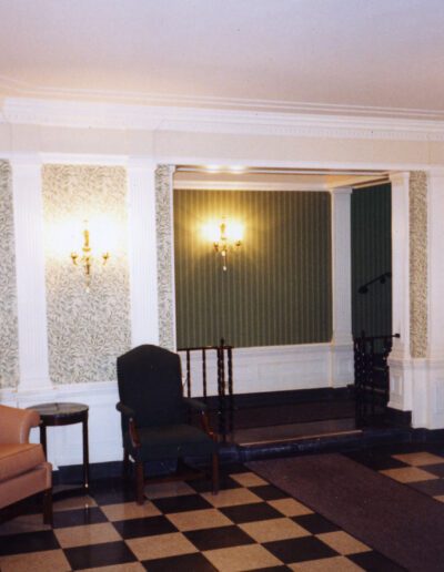 Elegant interior hallway with checkered floor, vintage wallpaper, and classic furniture.