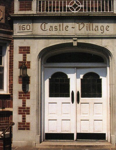 Entrance of the "castle village" building with double doors and the street number 160 displayed above.