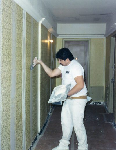 Man applying plaster to a wall during indoor renovations.