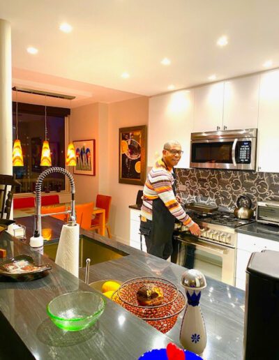 A person standing in a well-lit, modern kitchen with colorful decor.