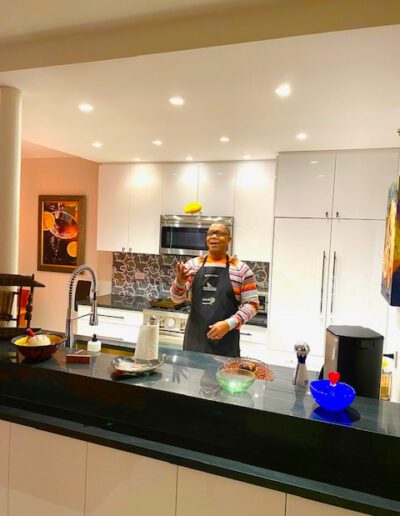 A person standing in a modern kitchen with cooking ingredients and utensils on the countertop.