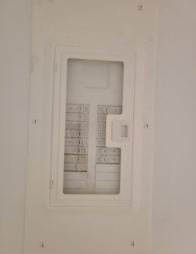 An open residential electrical circuit breaker panel mounted on a wall.