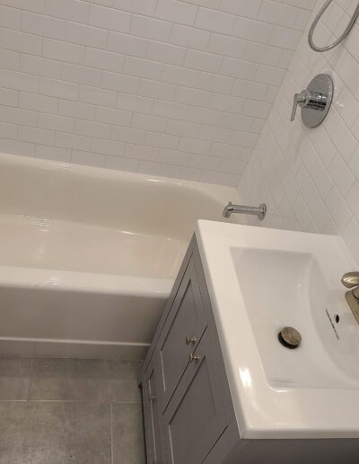 Modern bathroom interior with a white bathtub and sink.