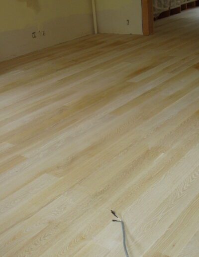 Newly installed light wooden flooring in an empty room.