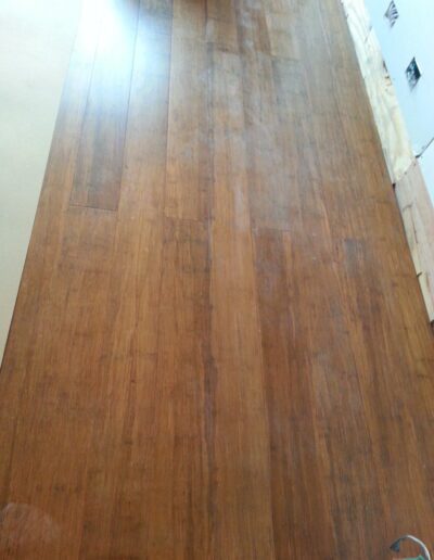 Wooden laminate flooring with visible seams and varying shades of brown.