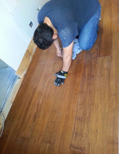 Man measuring wooden floor with a tape measure.