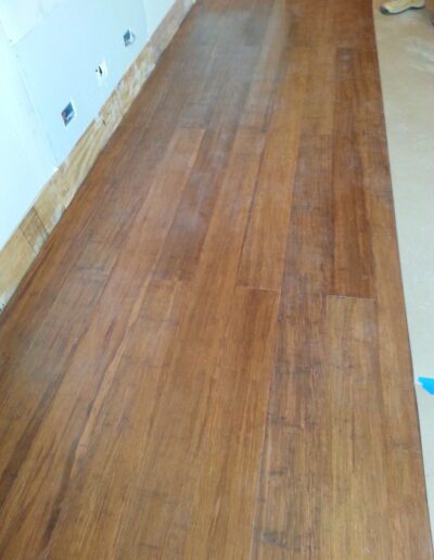 Newly installed brown laminate flooring in a room under renovation.