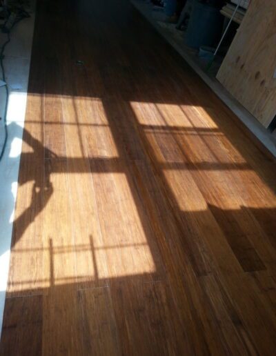 Sunlight casting shadows of window panes on a wooden floor.