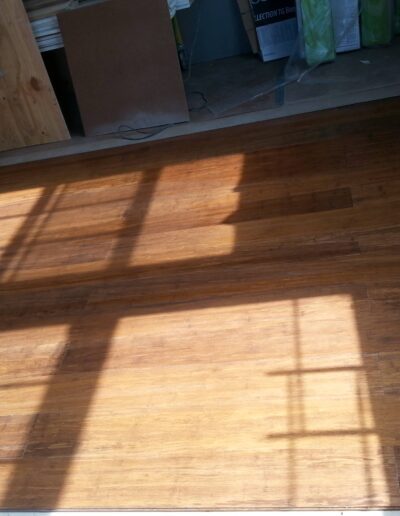 Sunlight casting shadows of window frames onto a wooden floor.