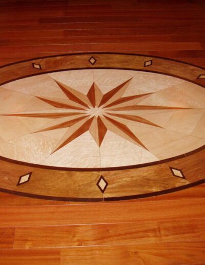 Elegant wooden floor inlay featuring a star design with geometric accents.