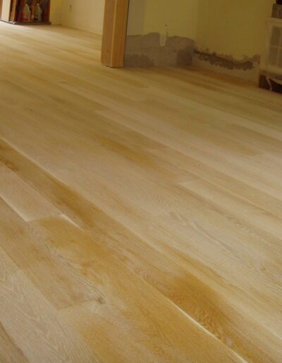 Unfinished wooden flooring installation in a room.