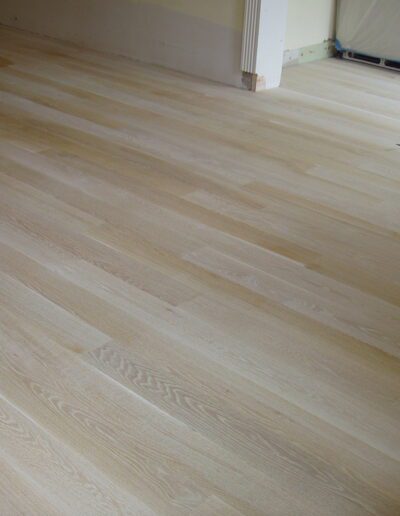 Newly installed unfinished hardwood flooring in a room.