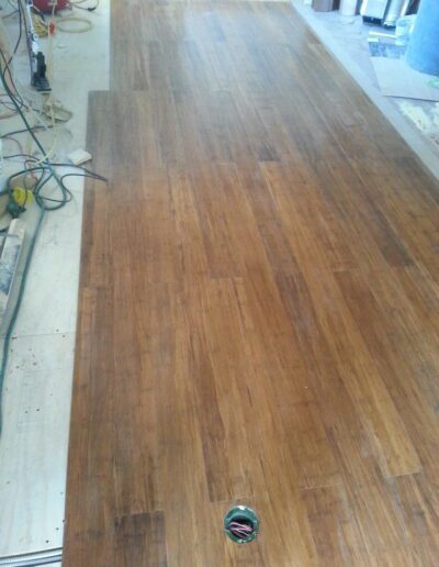 Partially installed hardwood flooring with tools in the background.