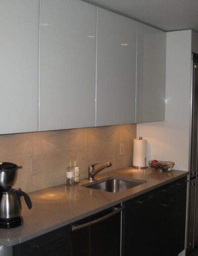 A modern kitchen with white cabinets, stainless steel appliances, and a blender on the countertop.