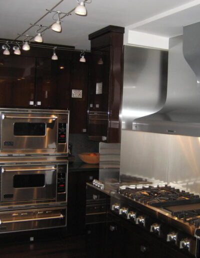 Modern kitchen with stainless steel appliances and dark wood cabinets.