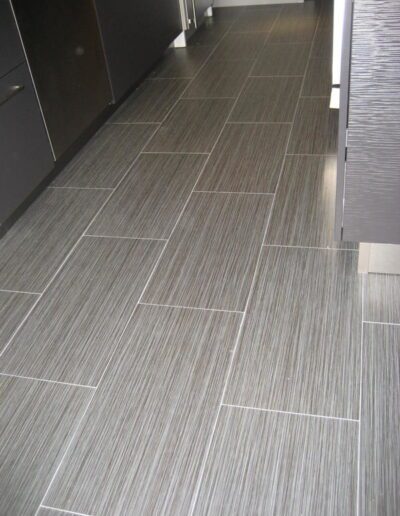 Modern kitchen with gray striped floor tiles.