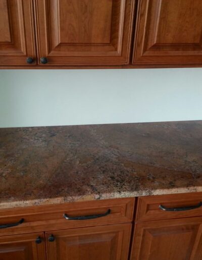 Wooden kitchen cabinets with a granite countertop.