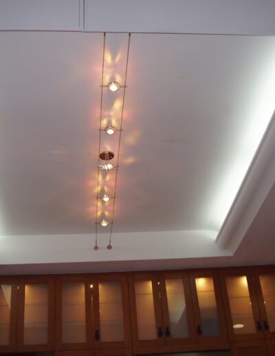 Modern interior with a false ceiling, recessed lighting, and a hanging pendant lamp fixture.