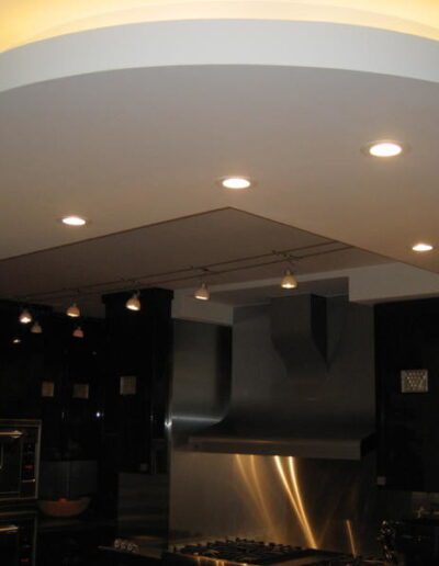 A modern kitchen interior with recessed lighting and stainless steel appliances.