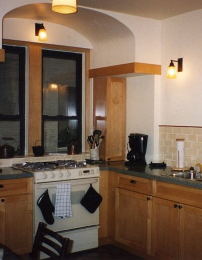 A well-lit, traditional kitchen with wooden cabinets and modern appliances.