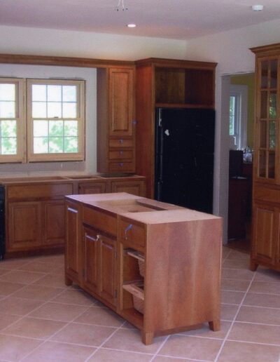 Spacious kitchen with wooden cabinets, an island, and tiled flooring.