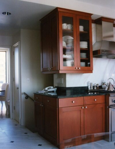 A kitchen corner with wooden cabinets, a countertop, and a phone.