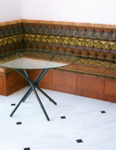 Corner nook with upholstered bench seating and a glass-top table.