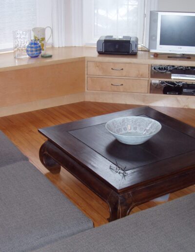 A tidy living room with a wooden coffee table, gray couches, and an entertainment system.