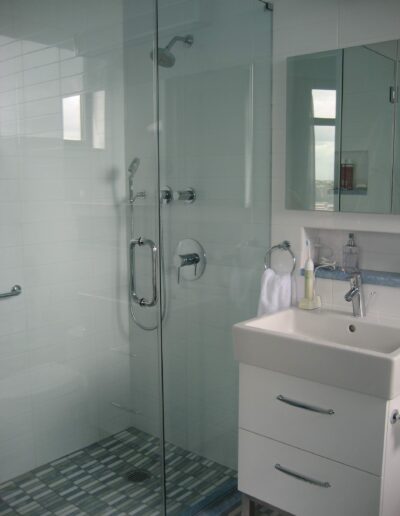 Modern bathroom interior with glass shower enclosure and white vanity sink.