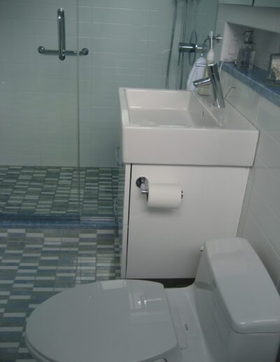 A small bathroom with a toilet, sink, and tiled floor.