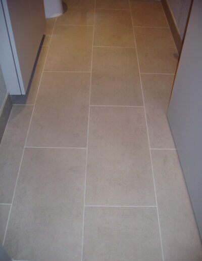 Modern tiled bathroom floor with neutral color scheme.