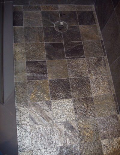 Tiled shower floor with central drain.