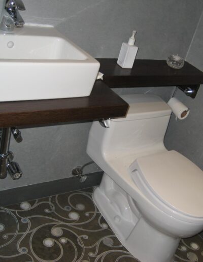 Modern bathroom with wall-mounted sink and patterned floor.