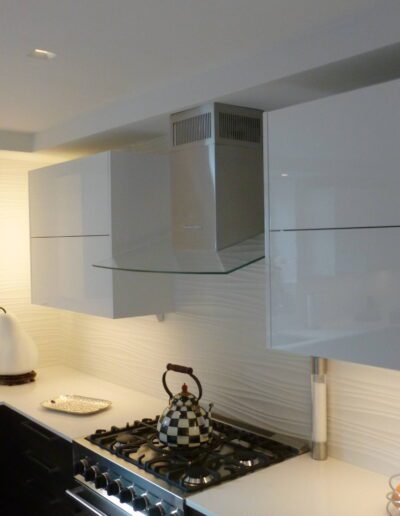 Modern kitchen with white cabinetry and stainless steel appliances.