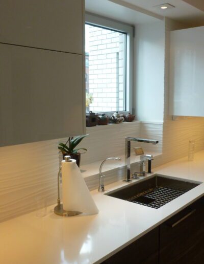 Modern kitchen interior with clean countertops and natural light coming through the window.