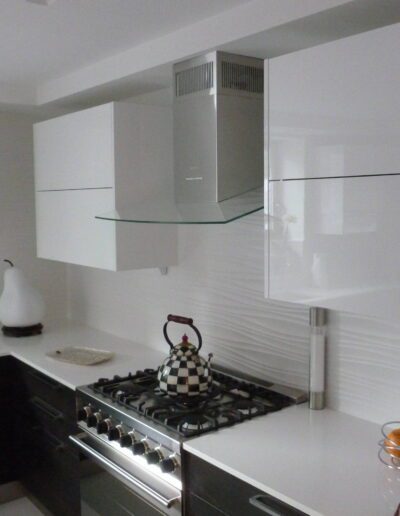 Modern kitchen with white cabinetry and stainless steel appliances.