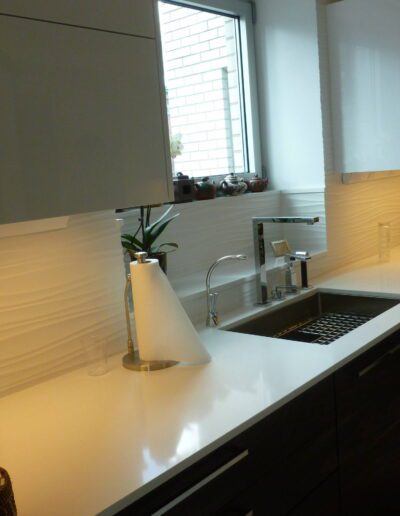 Modern kitchen interior with clean countertops, a sink, and decorative elements by the window.