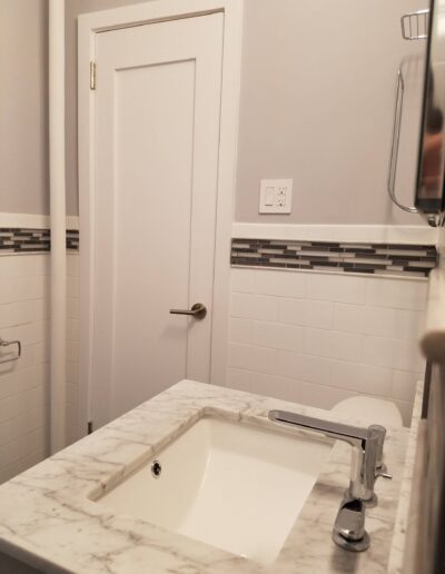 A clean, modern bathroom with a marble countertop and a closed door.