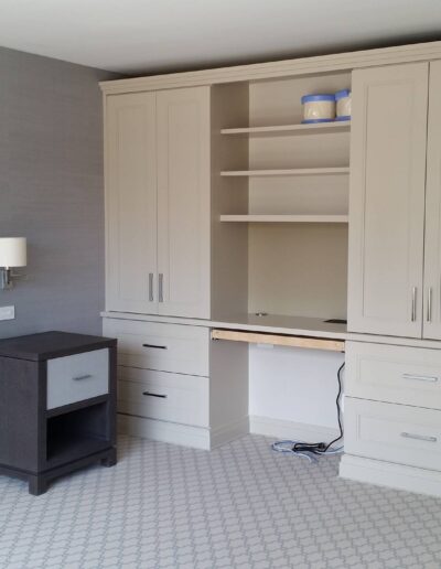 A modern home office with built-in shelves and desk, featuring a minimalist design and neutral colors.